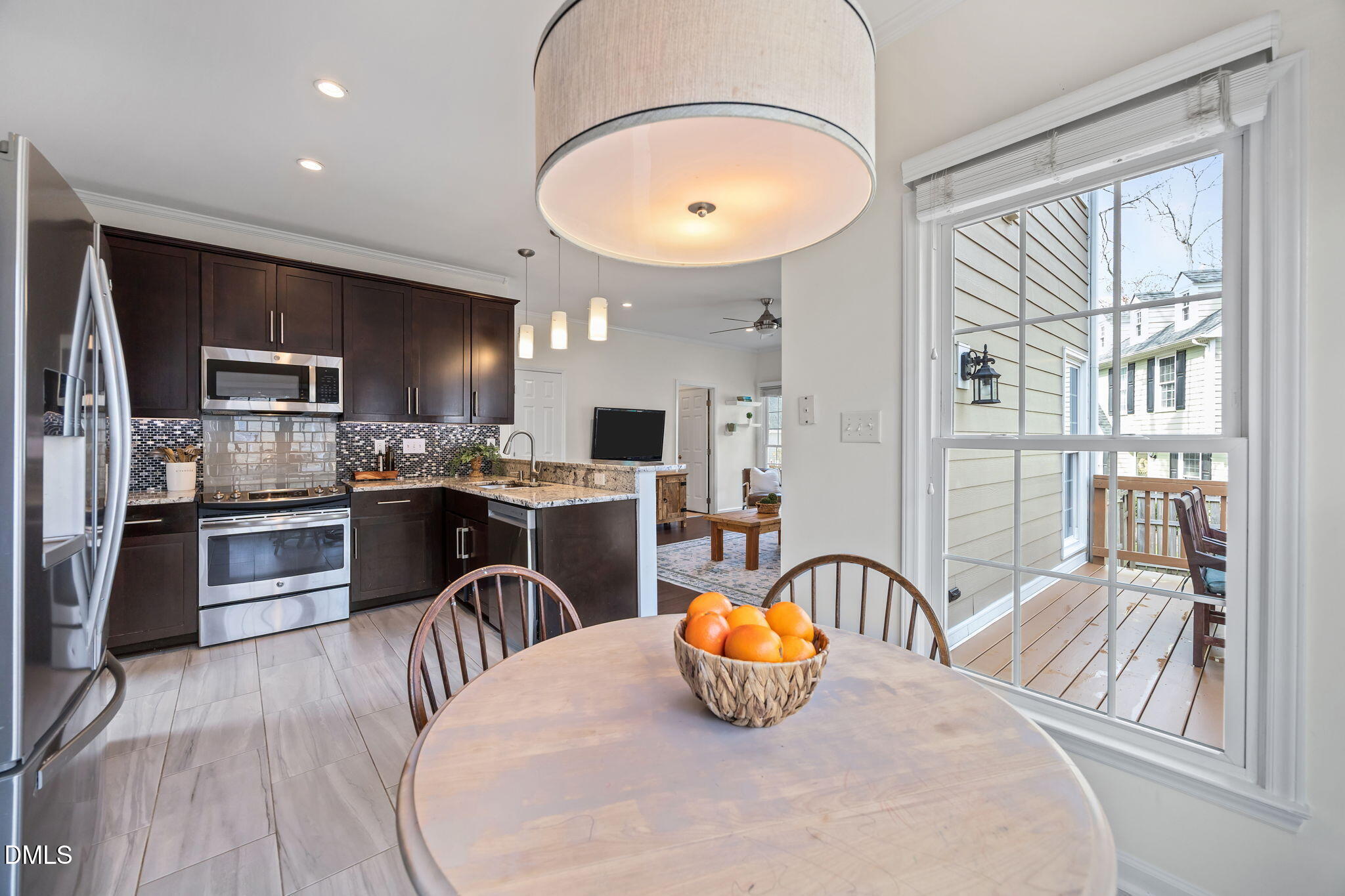 5512 Banwell Place Raleigh, NC 27613 - Photo 16 of 47 a kitchen with stainless steel appliances granite countertop a stove a refrigerator a kitchen island a dining table and chairs