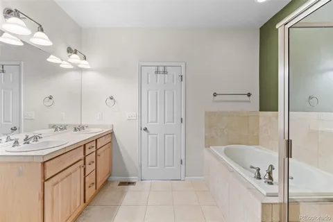 a bathroom with a tub a sink and a mirror