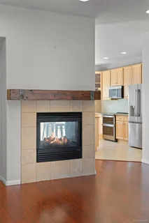 a kitchen with stainless steel appliances granite countertop a refrigerator a stove top oven a sink dishwasher and white cabinets with wooden floor