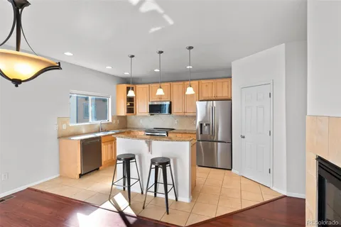 a kitchen with stainless steel appliances granite countertop a sink a stove and a wooden floors