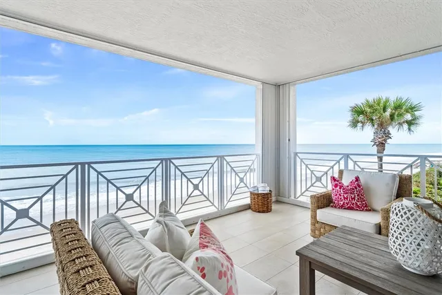 a living room with furniture and floor to ceiling window