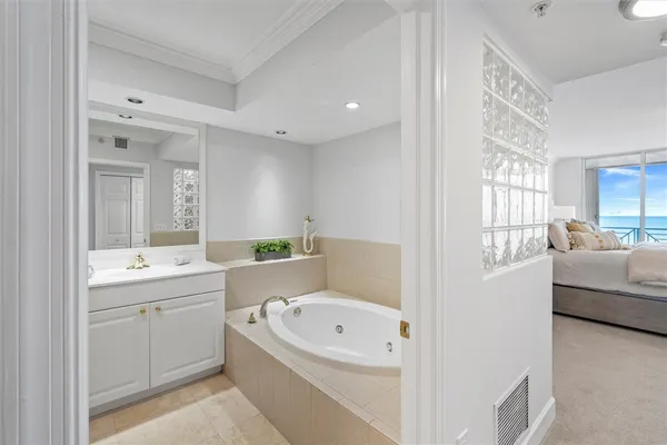 a bathroom with a bathtub a double vanity sink and mirrors
