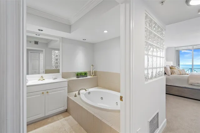 a bathroom with a bathtub a double vanity sink and mirrors