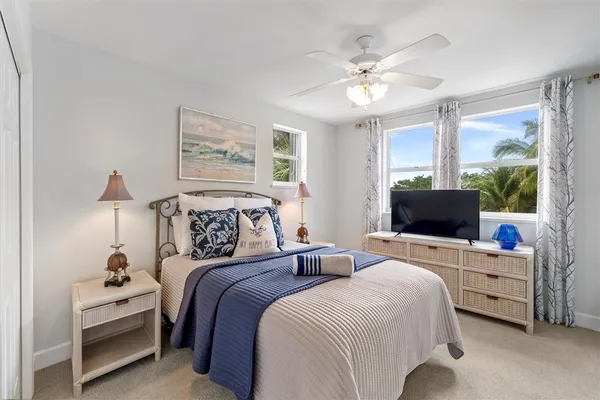 a bedroom with bed a lamp and a large window