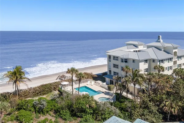 an aerial view of a house with a yard pool a table and chairs under an umbrella