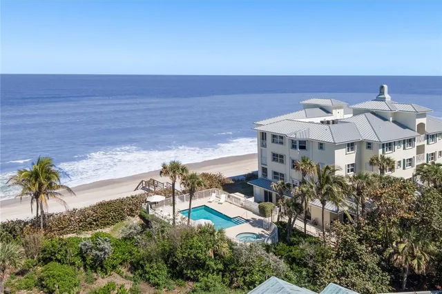 an aerial view of a house with a yard pool a table and chairs under an umbrella
