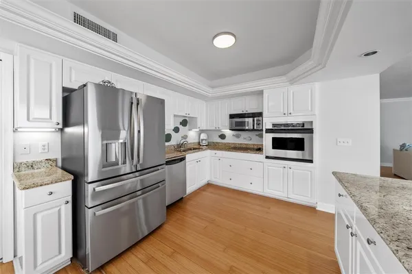 a kitchen with cabinets stainless steel appliances and a counter space