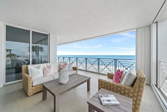 a living room with furniture and a floor to ceiling window
