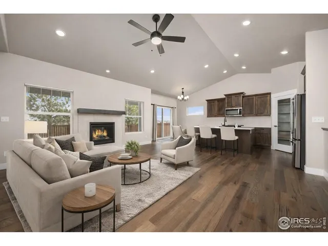 a living room with furniture kitchen view and a fireplace