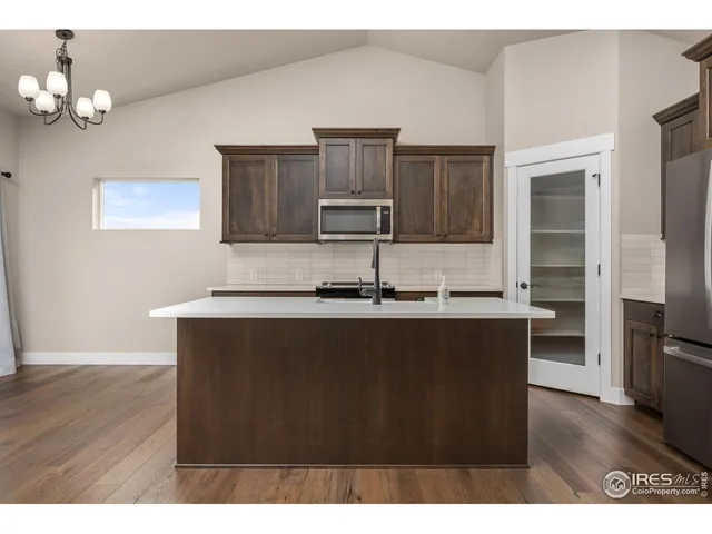 a kitchen with kitchen island granite countertop a sink cabinets and stainless steel appliances