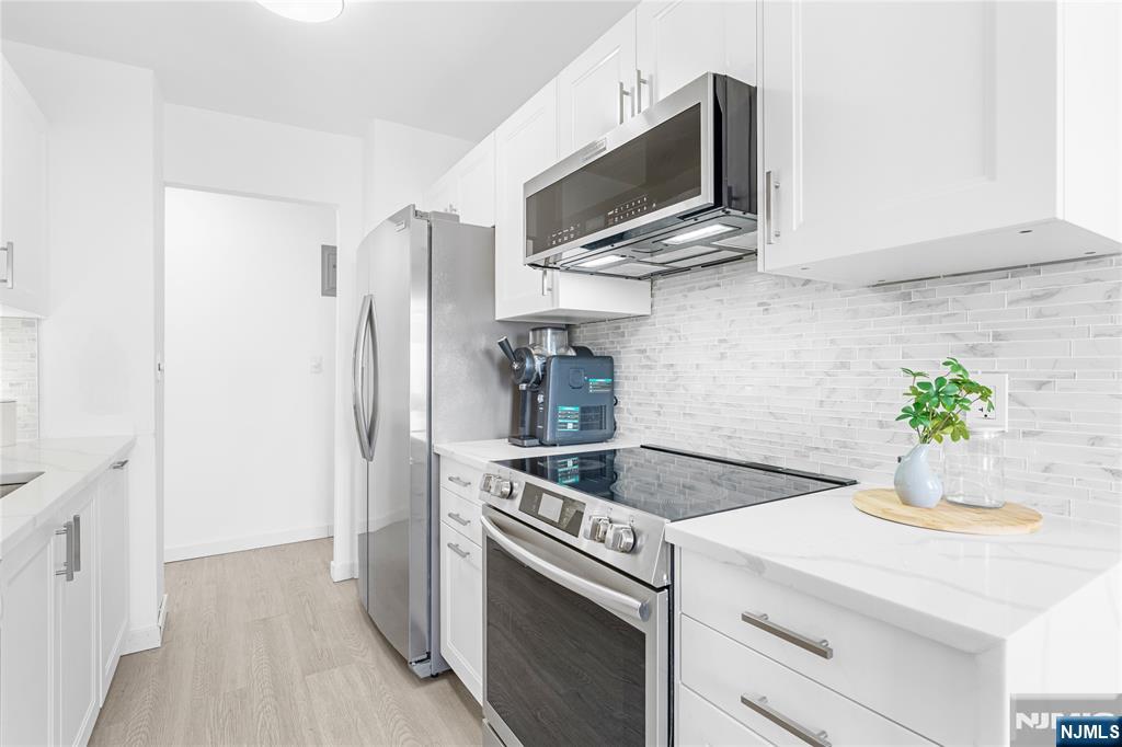 307 Prospect Avenue, Unit 17D Hackensack, NJ 07601 - Photo 6 of 29 a kitchen with stainless steel appliances granite countertop a refrigerator and a stove top oven