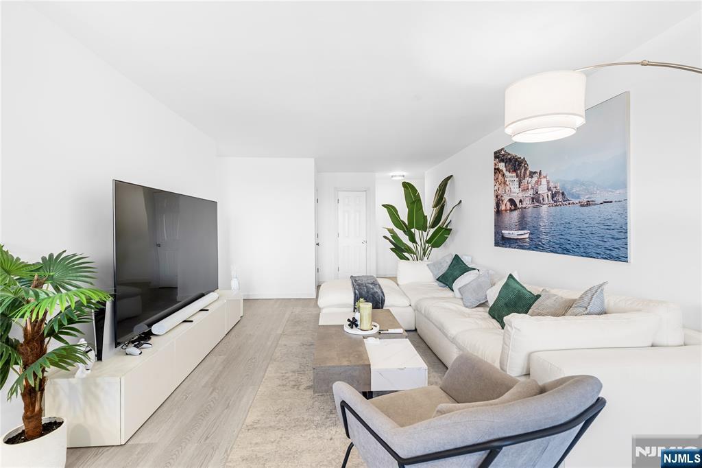 307 Prospect Avenue, Unit 17D Hackensack, NJ 07601 - Photo 10 of 29 a living room with furniture and a flat screen tv