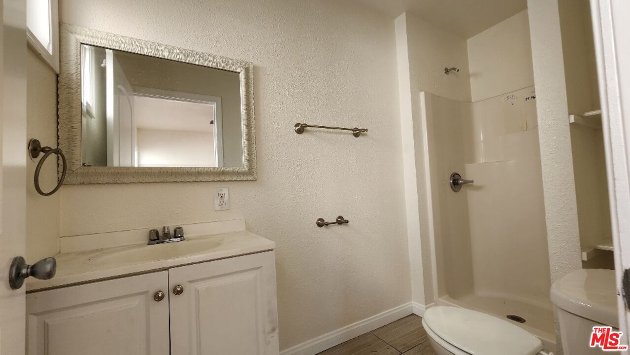251 West 41st Place Los Angeles, CA 90037 - Photo 18 of 18 a bathroom with a shower sink and mirror