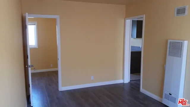 an empty room with wooden floor and closet