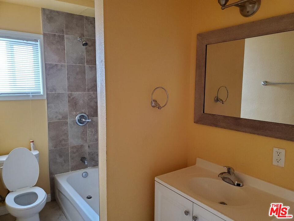 251 West 41st Place Los Angeles, CA 90037 - Photo 10 of 18 a bathroom with a sink mirror vanity and toilet