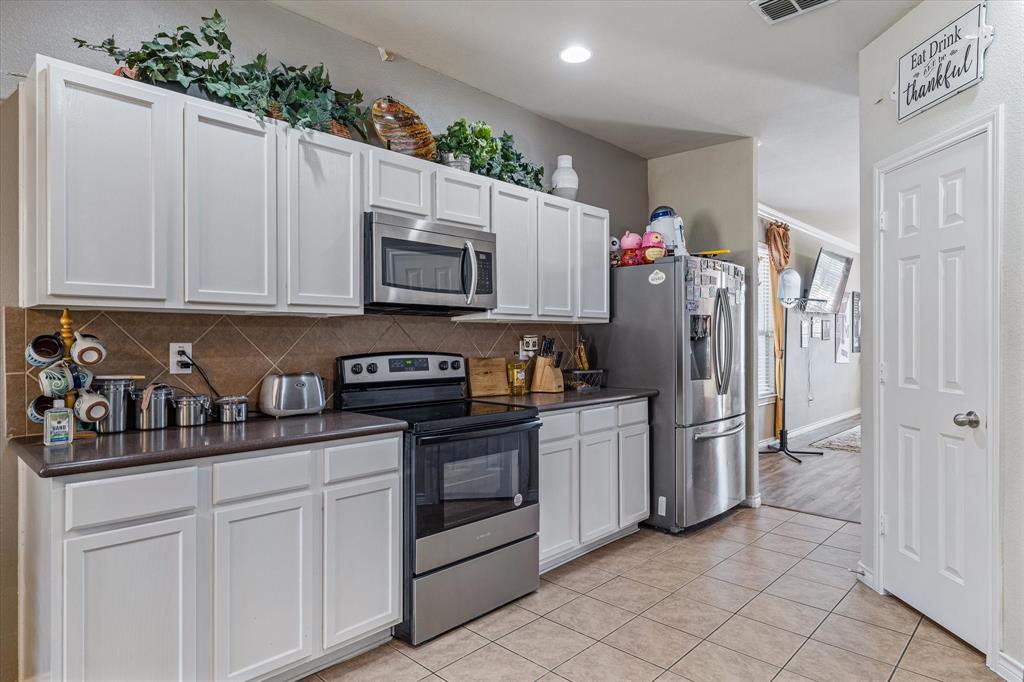 503 Sundrop Lane Fate, TX 75087 - Photo 12 of 28 a kitchen with stainless steel appliances granite countertop a refrigerator sink and cabinets