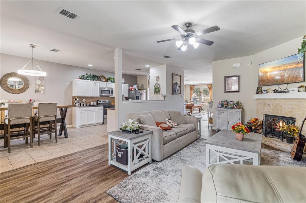 503 Sundrop Lane Fate, TX 75087 - Photo 9 of 28 a living room with furniture kitchen view and a fireplace
