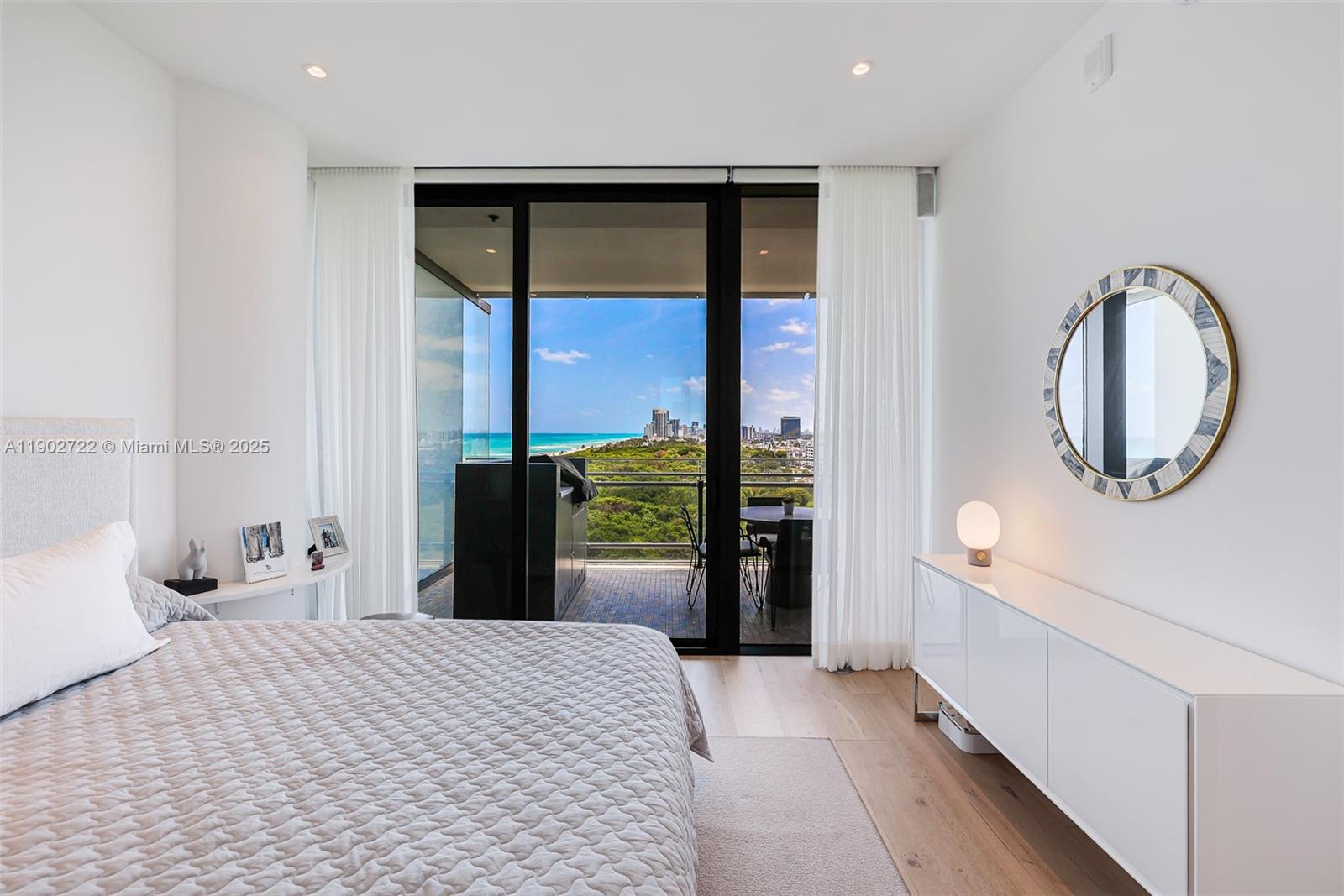 8701 Collins Avenue, Unit 904 Miami Beach, FL 33154 - Photo 41 of 73 a bedroom with a bed and a large mirror