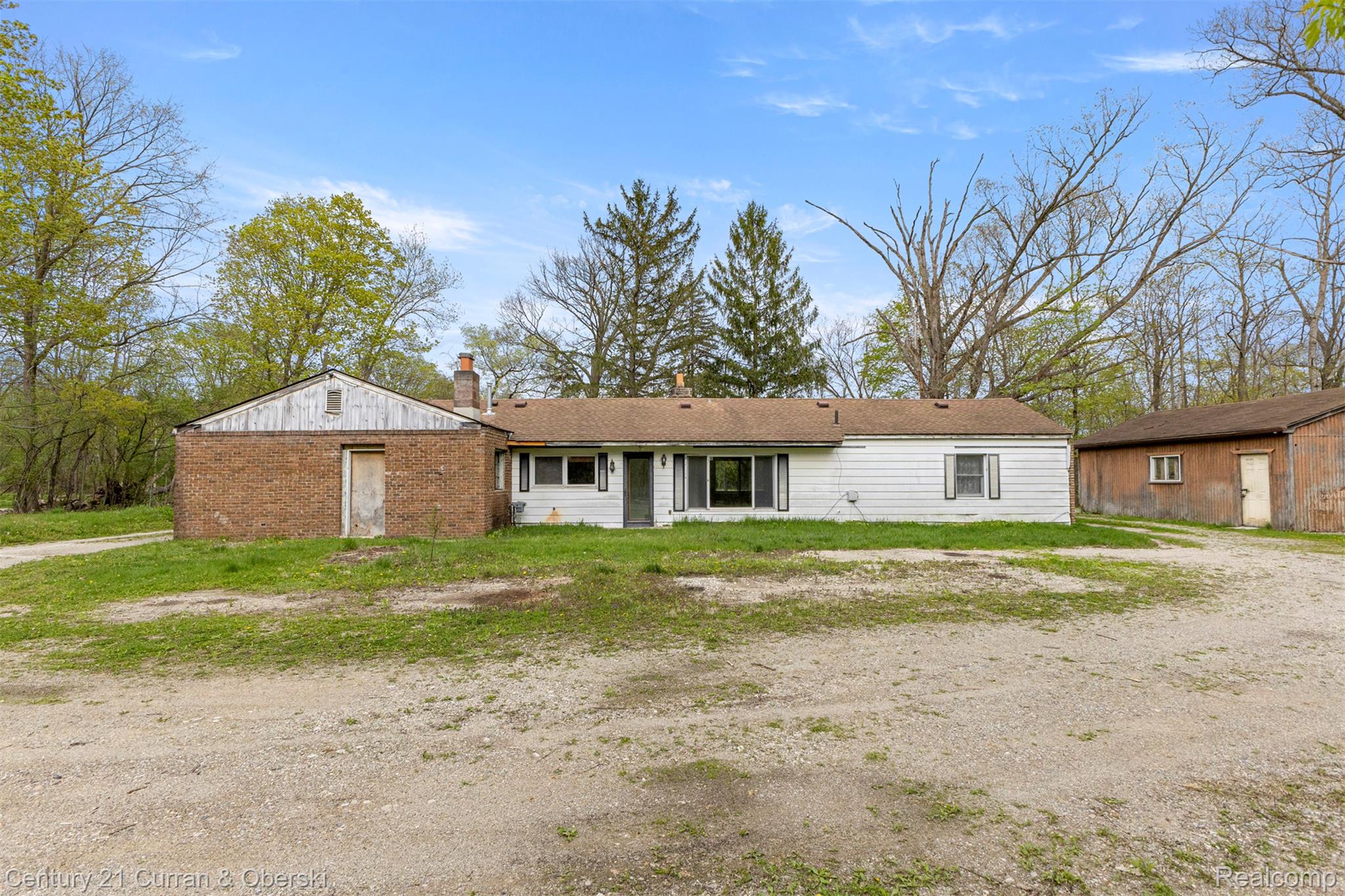 25205 Inkster Road Farmington, MI 48336 - Photo 33 of 46 View of front facade featuring a chimney and an outbuilding