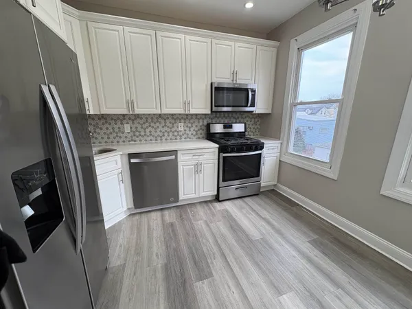 a kitchen with granite countertop a stove top oven a sink and a microwave