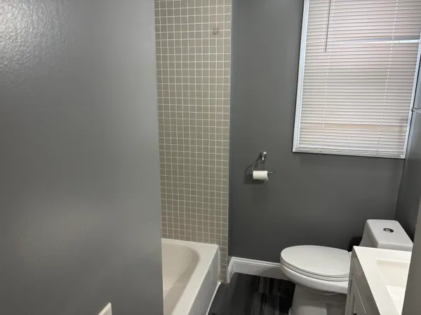 a white toilet sitting next to a bathroom sink