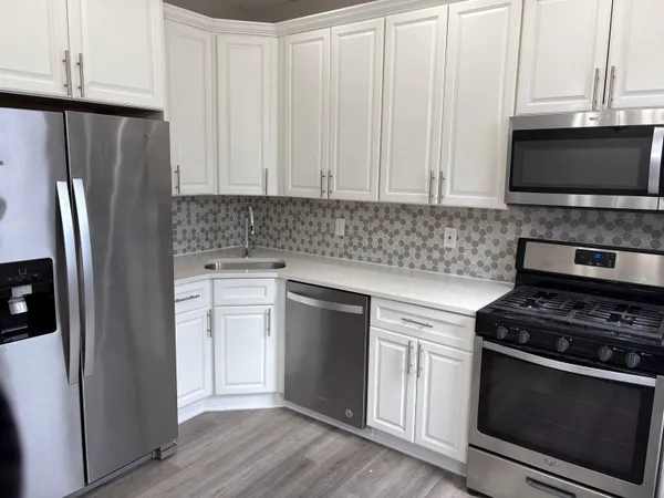a kitchen with stainless steel appliances a stove a microwave and a refrigerator