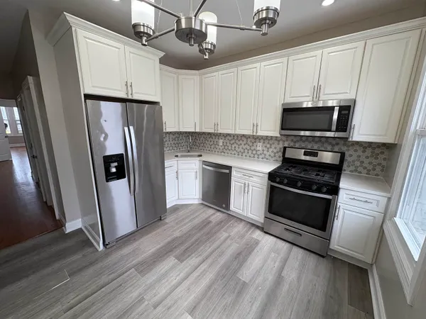a kitchen with stainless steel appliances a refrigerator sink and microwave