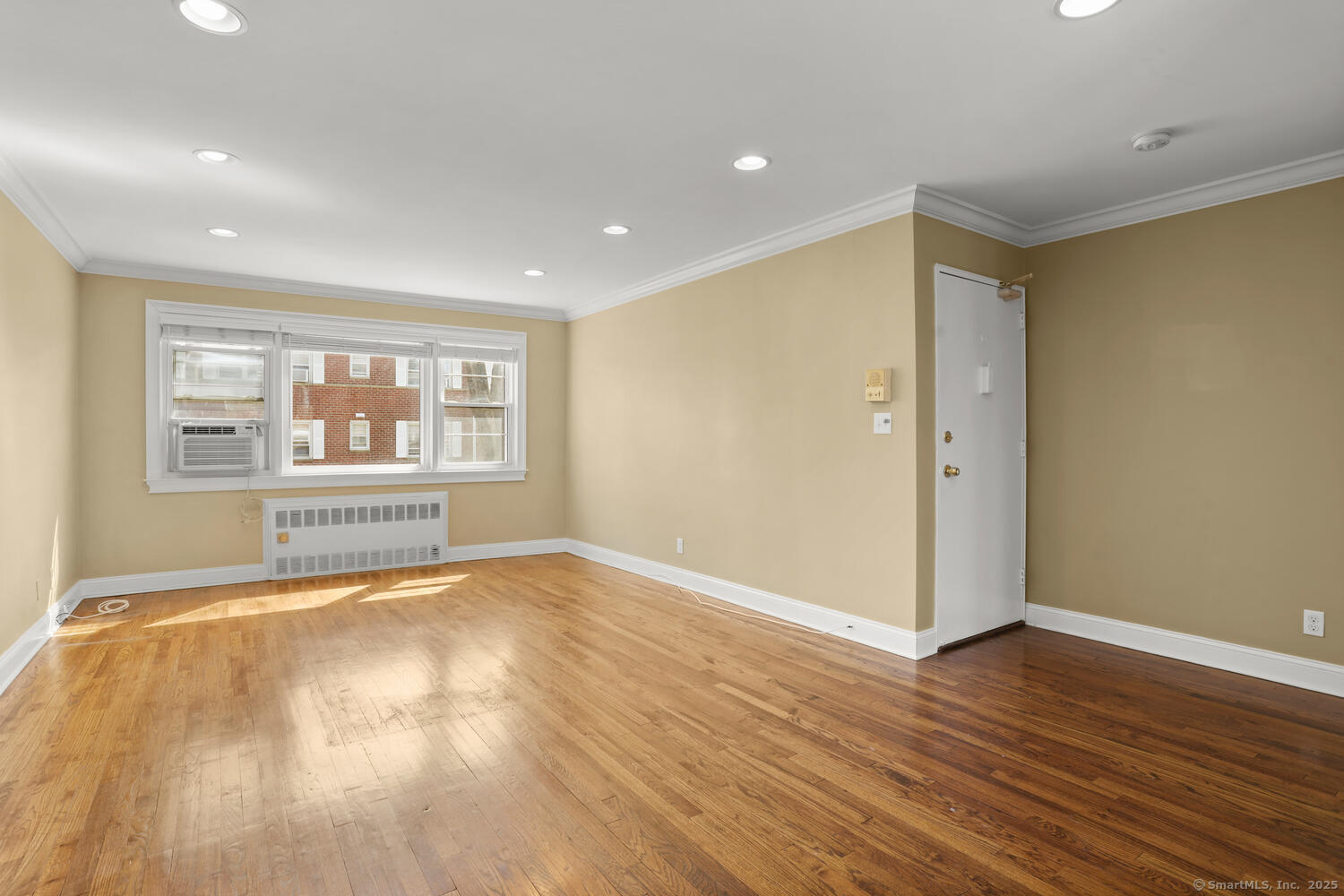 236 Glenbrook Road, Unit 13A Stamford, CT 06906 - Photo 5 of 14 a view of an empty room with wooden floor and a window