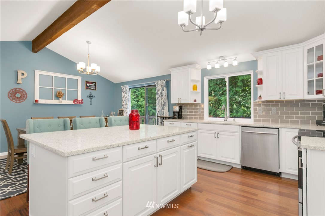 1823 175th Place Southeast Bothell, WA 98012 - Photo 9 of 24 a kitchen with a sink dishwasher a stove and white cabinets with wooden floor
