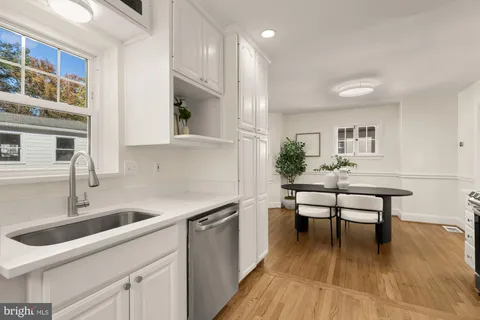 a kitchen with a sink cabinets and wooden floor