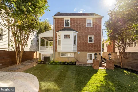 a view of a house with backyard and a tree