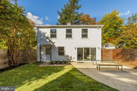 a kitchen with a table chairs and white cabinets