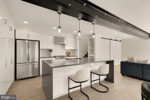 a kitchen with kitchen island a counter space a sink appliances and cabinets