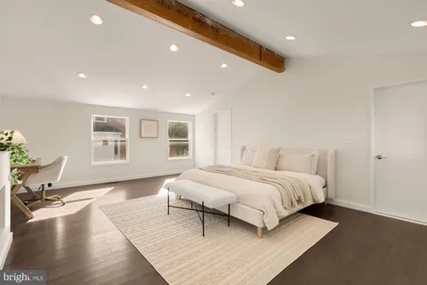 a spacious bedroom with a bed and a lamp
