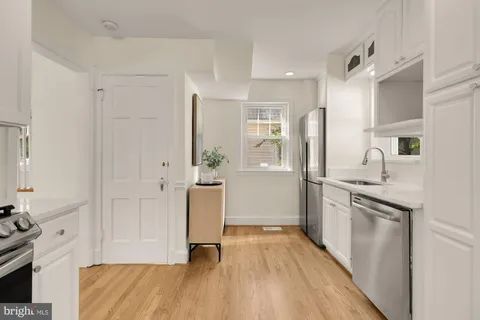 a kitchen with white cabinets and stainless steel appliances
