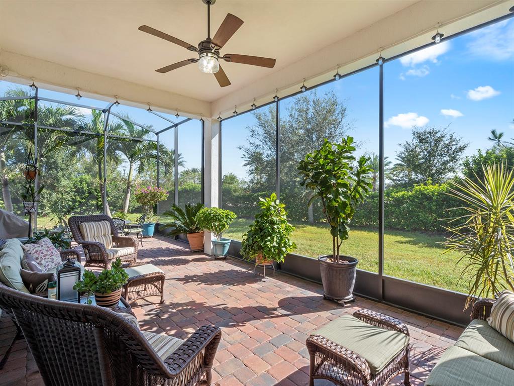 2600 Meadowedge Loop St. Cloud, FL 34772 - Photo 18 of 82 a view of a patio with a table chairs potted plants and a palm tree