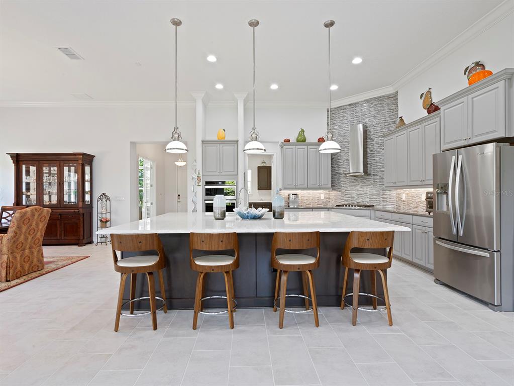 2600 Meadowedge Loop St. Cloud, FL 34772 - Photo 4 of 82 a kitchen with stainless steel appliances granite countertop a table chairs sink refrigerator and microwave