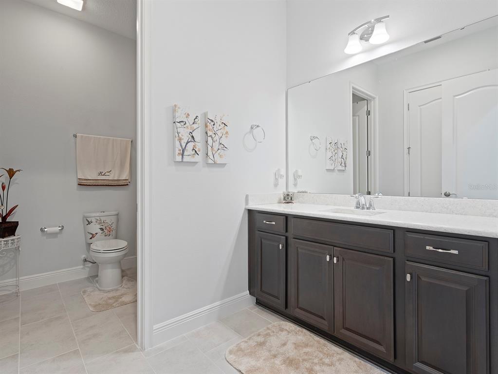 2600 Meadowedge Loop St. Cloud, FL 34772 - Photo 49 of 82 a bathroom with a toilet sink and mirror
