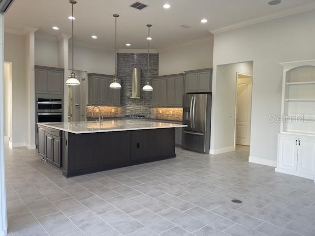 2600 Meadowedge Loop St. Cloud, FL 34772 - Photo 8 of 82 a large kitchen with a large counter top stainless steel appliances and cabinets