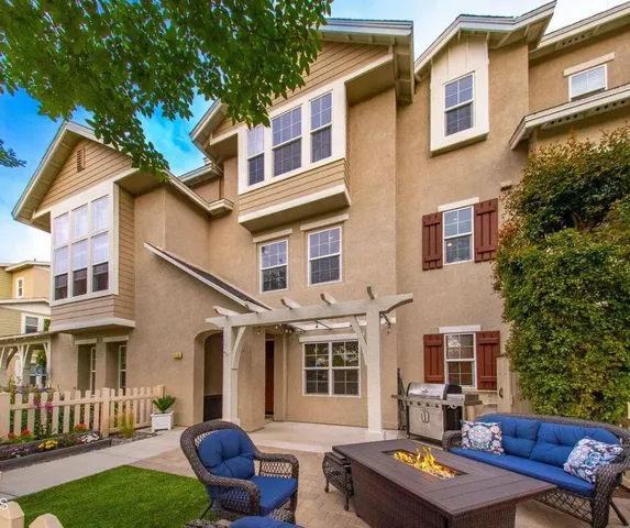 a view of a patio with couches table and chairs and potted plants