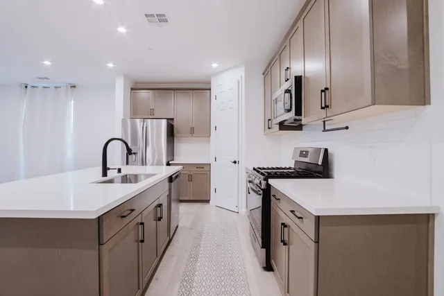 a kitchen with stainless steel appliances granite countertop a sink stove and cabinets