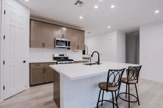 a kitchen that has a microwave a stove a table and chairs in it