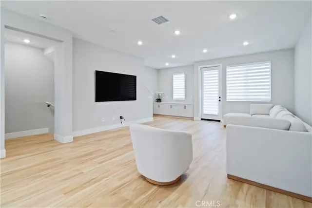 a view of a livingroom with an empty space and wooden floor