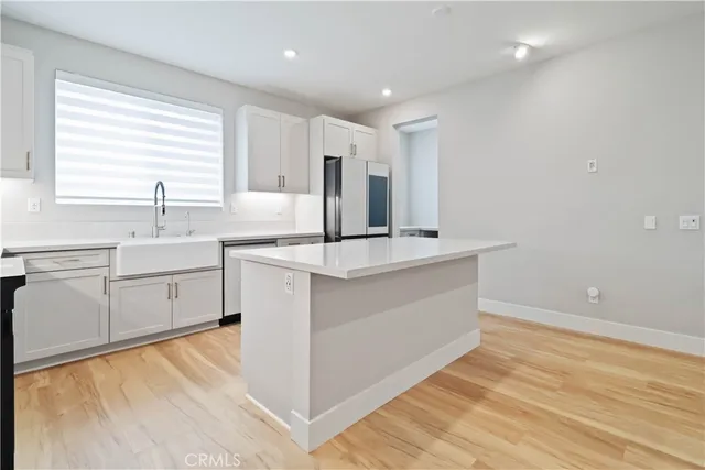 a large kitchen with stainless steel appliances kitchen island a large counter top and a sink