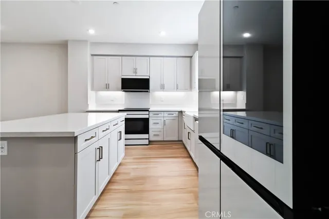a kitchen with stainless steel appliances a stove microwave and sink
