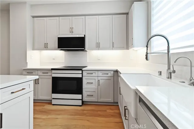a kitchen with a sink refrigerator and microwave