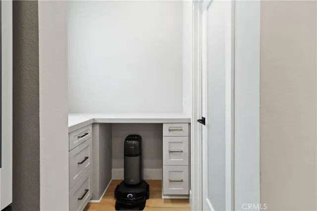 a view of a workspace with furniture and a window