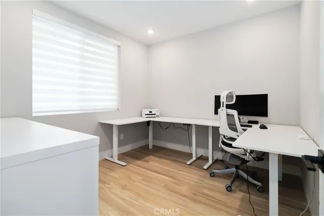 a view of a workspace with furniture and wooden floor