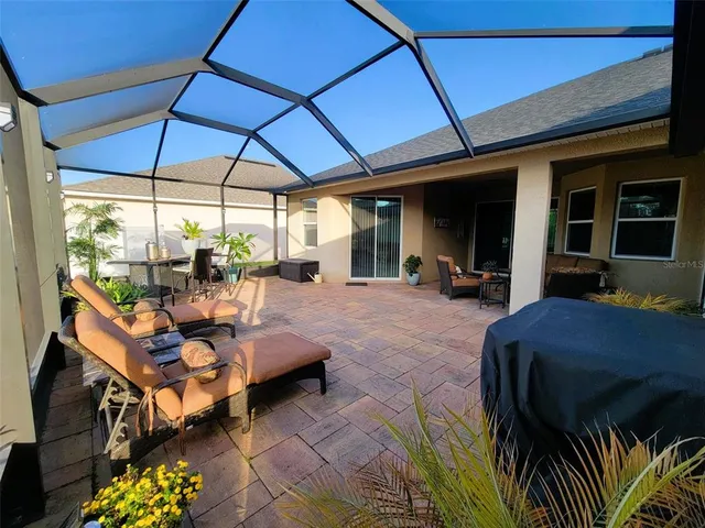 a view of a patio with table and chairs under an umbrella