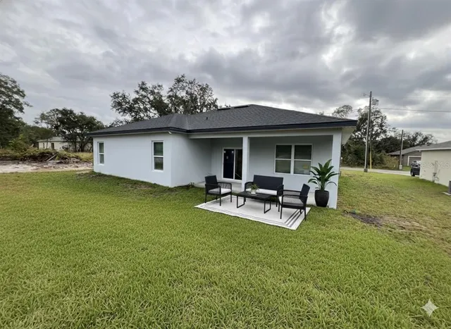 a view of a house with backyard porch and sitting area
